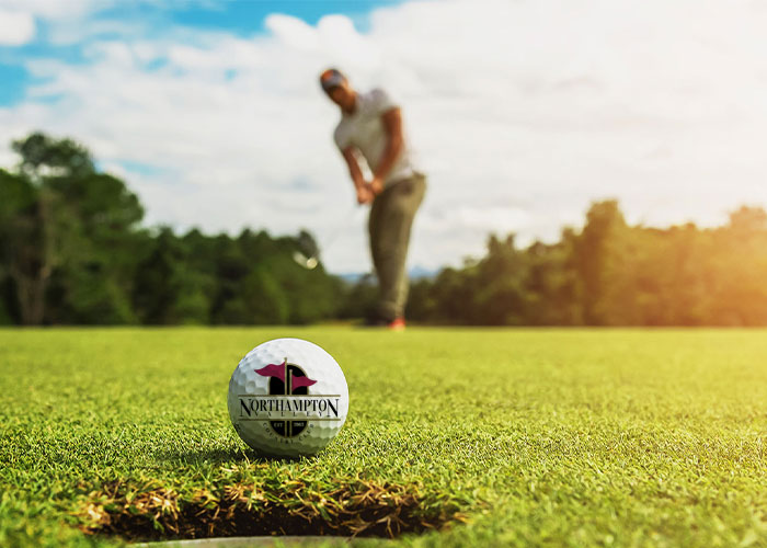 golfer putting ball with course logo